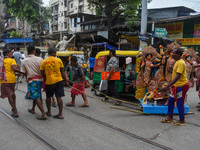 Laborers carry an idol of Goddess Durga to her pandal ahead of the Durga Puja festival in Kolkata, India, on October 2024. (