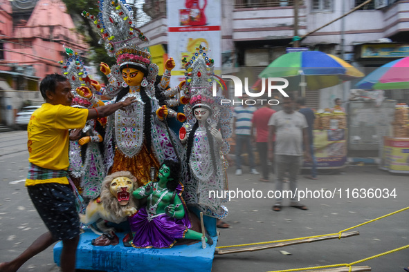 Laborers carry an idol of Goddess Durga to her pandal ahead of the Durga Puja festival in Kolkata, India, on October 2024. 