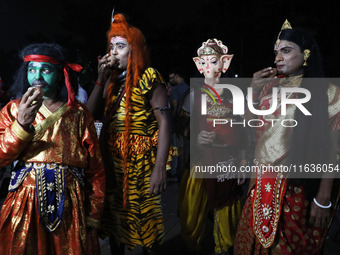 Performers dress as Hindu gods, and a performer dressed as goddess Durga drinks tea at a tea stall in Kolkata, India, on October 4, 2024. Th...