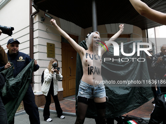 (EDITORS NOTE: Image contains nudity and profanity.) A barechested Femen activist, with a slogan marked on her body, protests against Tehran...