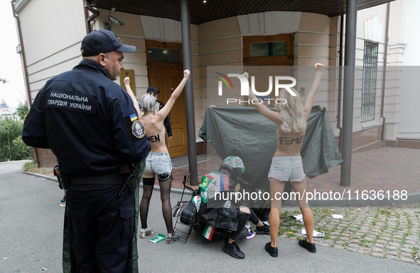 Barechested Femen activists, with the name of the movement marker written on their backs, protest against Tehran's military support of Russi...