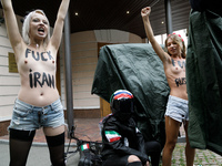 (EDITORS NOTE: Image contains nudity and profanity.) Barechested Femen activists, with slogans written on their bodies, protest against Tehr...