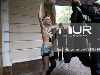 (EDITORS NOTE: Image contains nudity and profanity.) A barechested Femen activist, with a slogan marked on her body, protests against Tehran...