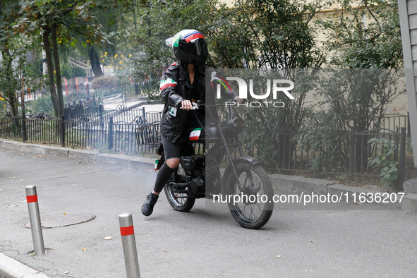 A Femen activist heads towards the Embassy of Iran on a moped to take part in a protest against Tehran's military support of Russia in Kyiv,...