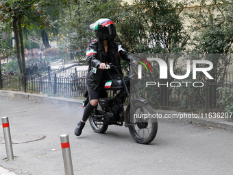 A Femen activist heads towards the Embassy of Iran on a moped to take part in a protest against Tehran's military support of Russia in Kyiv,...