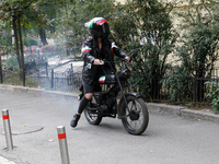 A Femen activist heads towards the Embassy of Iran on a moped to take part in a protest against Tehran's military support of Russia in Kyiv,...