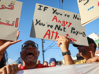 A man shouts slogans against President Kais Saied as he raises a placard that reads, ''If you are not angry, you are not paying attention,''...