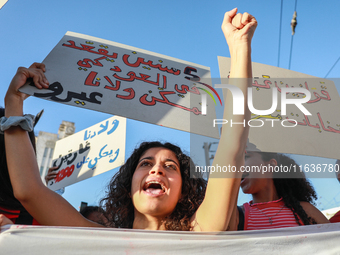 A young woman shouts slogans against President Kais Saied as she raises a placard that reads in Arabic, ''five years in power and nothing do...