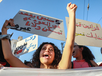 A young woman shouts slogans against President Kais Saied as she raises a placard that reads in Arabic, ''five years in power and nothing do...