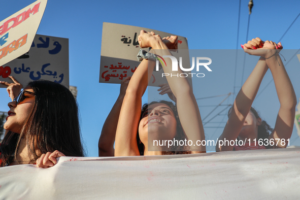 Demonstrators with clenched fists above their heads shout slogans against President Kais Saied during a demonstration organized by the Tunis...