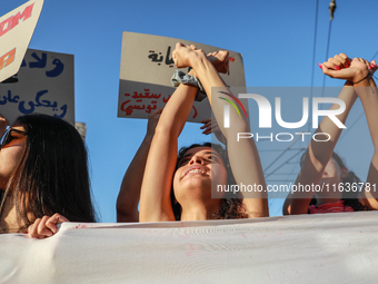 Demonstrators with clenched fists above their heads shout slogans against President Kais Saied during a demonstration organized by the Tunis...