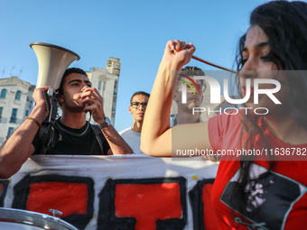 A young demonstrator shouts slogans against President Kais Saied on a megaphone during a demonstration organized by the Tunisian Network for...