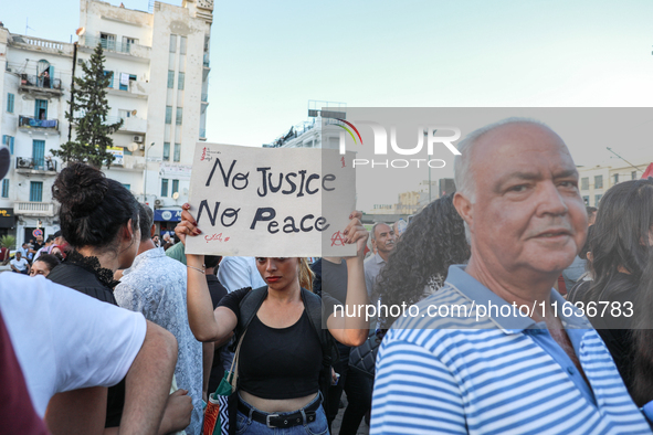 A young woman raises a placard that reads in Arabic, ''no justice no peace,'' during a demonstration organized by the Tunisian Network for R...