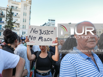 A young woman raises a placard that reads in Arabic, ''no justice no peace,'' during a demonstration organized by the Tunisian Network for R...