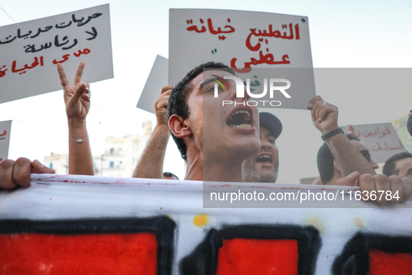 A young man shouts slogans against President Kais Saied, while others raise placards during a demonstration organized by the Tunisian Networ...