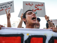 A young man shouts slogans against President Kais Saied, while others raise placards during a demonstration organized by the Tunisian Networ...