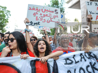 A young woman shouts slogans against President Kais Saied as she raises a placard that reads in Arabic, ''five years in power and nothing do...