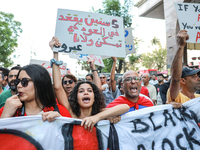 A young woman shouts slogans against President Kais Saied as she raises a placard that reads in Arabic, ''five years in power and nothing do...