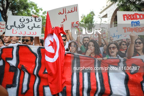 Demonstrators shout slogans against President Kais Saied as they raise placards and the national flag of Tunisia during a demonstration orga...