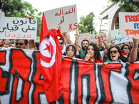 Demonstrators shout slogans against President Kais Saied as they raise placards and the national flag of Tunisia during a demonstration orga...