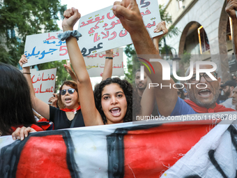 Demonstrators shout slogans against President Kais Saied as they raise their fists during a demonstration organized by the Tunisian Network...