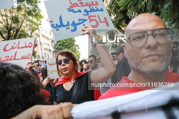 A woman raises a placard that reads in Arabic, ''Down with the system of 54 July,'' during a demonstration organized by the Tunisian Network...