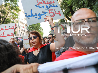 A woman raises a placard that reads in Arabic, ''Down with the system of 54 July,'' during a demonstration organized by the Tunisian Network...