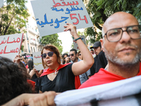 A woman raises a placard that reads in Arabic, ''Down with the system of 54 July,'' during a demonstration organized by the Tunisian Network...