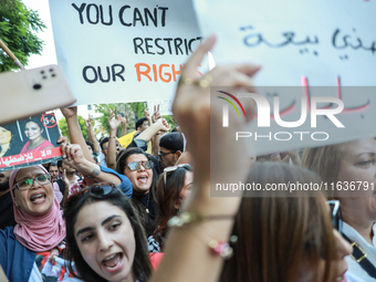 Demonstrators shout slogans against President Kais Saied and raise a placard that reads, ''You cannot resist our rights,'' during a demonstr...