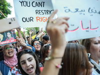 Demonstrators shout slogans against President Kais Saied and raise a placard that reads, ''You cannot resist our rights,'' during a demonstr...