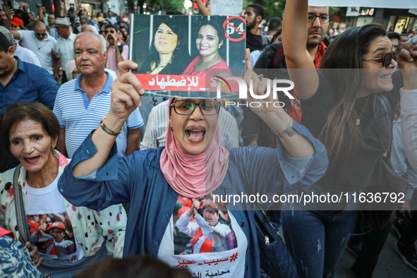 A woman shouts slogans against President Kais Saied as she raises a portrait of the imprisoned leader of the Free Constitutional Party (PDL)...