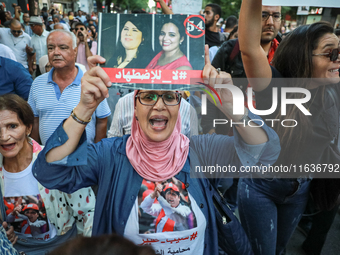 A woman shouts slogans against President Kais Saied as she raises a portrait of the imprisoned leader of the Free Constitutional Party (PDL)...