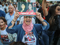 A woman shouts slogans against President Kais Saied as she raises a portrait of the imprisoned leader of the Free Constitutional Party (PDL)...