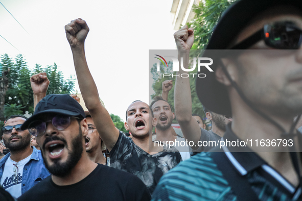 Young demonstrators shout slogans against President Kais Saied and raise their fists during a demonstration organized by the Tunisian Networ...