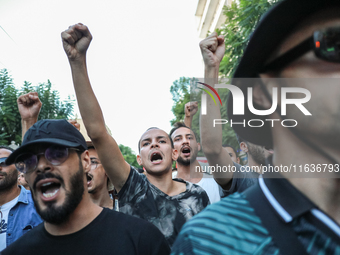 Young demonstrators shout slogans against President Kais Saied and raise their fists during a demonstration organized by the Tunisian Networ...