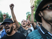 Young demonstrators shout slogans against President Kais Saied and raise their fists during a demonstration organized by the Tunisian Networ...