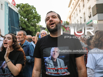 Elyes Chaouachi, son of political prisoner Ghazi Chaouachi, wears a T-shirt bearing a photo of his father and attends a demonstration organi...