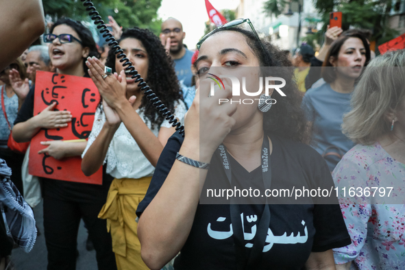 A young woman wears a T-shirt that reads ''Feminists'' in Arabic and shouts slogans against President Kais Saied on a megaphone during a dem...