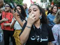 A young woman wears a T-shirt that reads ''Feminists'' in Arabic and shouts slogans against President Kais Saied on a megaphone during a dem...