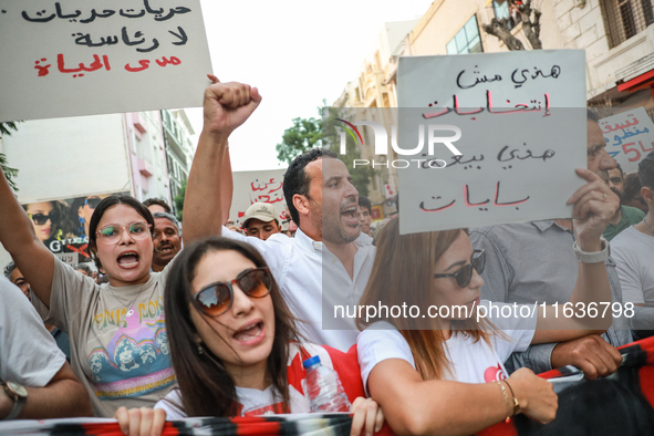 A woman (L) raises a placard that reads in Arabic, ''freedom, freedom, no presidency for lifetime,'' as others raise fists while shouting sl...