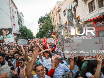 Hundreds of Tunisians raise their arms as they shout ''Degage'' (English: get out) during a demonstration organized by the Tunisian Network...