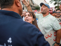 A young Tunisian woman faces a security forces member during a demonstration organized by the Tunisian Network for Rights and Freedoms in Tu...