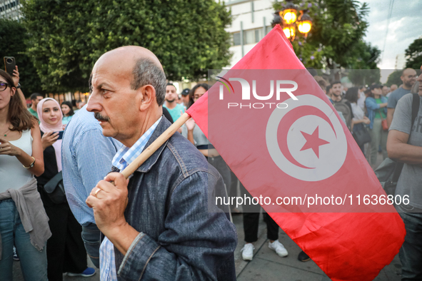 A man with the national flag of Tunisia on his shoulder attends a demonstration organized by the Tunisian Network for Rights and Freedoms in...