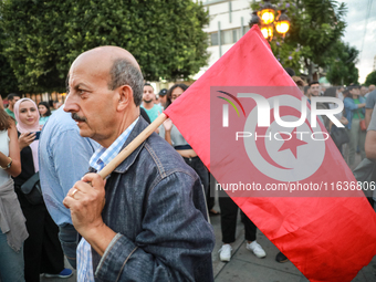 A man with the national flag of Tunisia on his shoulder attends a demonstration organized by the Tunisian Network for Rights and Freedoms in...