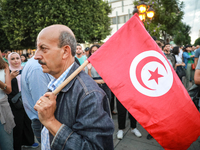 A man with the national flag of Tunisia on his shoulder attends a demonstration organized by the Tunisian Network for Rights and Freedoms in...