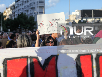 A young Tunisian woman raises a placard that reads in Arabic, ''Down with Decree 54,'' during a demonstration organized by the Tunisian Netw...