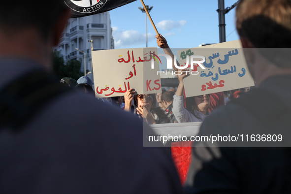 Demonstrators raise a placard that reads in Arabic, ''justice or chaos,'' during a demonstration organized by the Tunisian Network for Right...