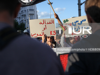 Demonstrators raise a placard that reads in Arabic, ''justice or chaos,'' during a demonstration organized by the Tunisian Network for Right...