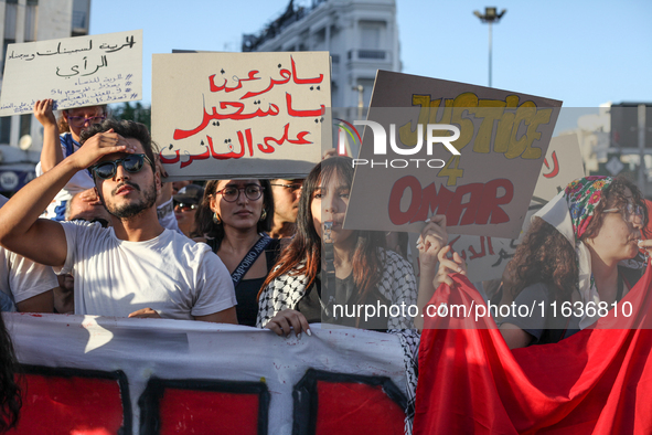 Demonstrators raise a placard that reads in Arabic, ''O Pharaoh, you who transgress the law,'' during a demonstration organized by the Tunis...