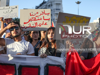 Demonstrators raise a placard that reads in Arabic, ''O Pharaoh, you who transgress the law,'' during a demonstration organized by the Tunis...